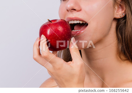 Morning breakfast. Woman with healthy teeth holding apples on grey isolated background. Morning breakfast. Woman with healthy teeth holding apples on grey isolated background. 108255642