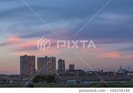 The sky dyed in the sunset, buildings, buildings, riverbed, sunset, people gathering at sunset, sunset sky, silhouettes of people 108256146