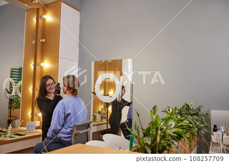 Brow Shaping, Eyebrow Design, Salon Experience. Woman is participating in beauty treatment that involves precise eyebrow correction and microblading at salon. Copy space 108257709