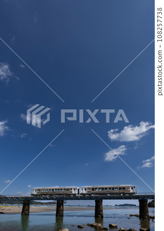 Under the blue sky, the limited express train runs on the iron bridge over the Hosoda River. Under the blue sky, the limited express train runs on the iron bridge over the Hosoda River. 108257738