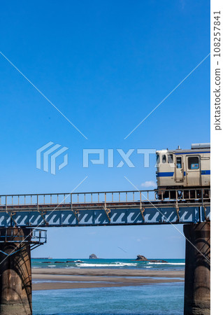 Kiha 40 on the Nichinan Line running on the iron bridge over the Hosoda River under the blue sky 108257841