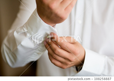 Close-up of a Man Fastening Cufflink on White Shirt Sleeve Close-up of a Man Fastening Cufflink on White Shirt Sleeve 108258887