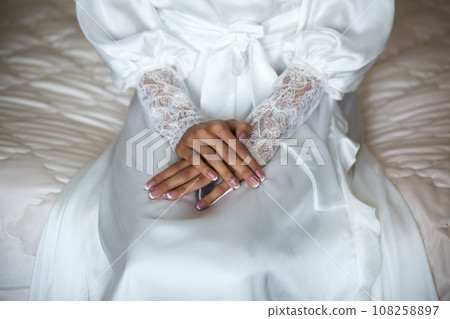 Bride's Hands with Lace Sleeves on Satin Dress Bride's Hands with Lace Sleeves on Satin Dress 108258897