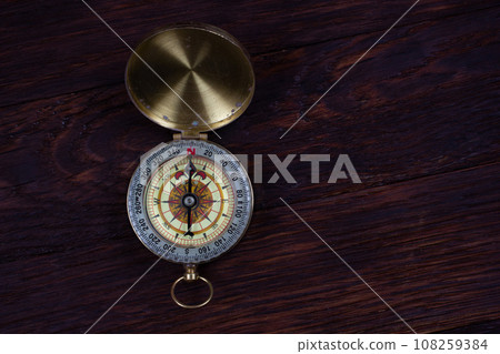 Vintage retro compass on wooden background 108259384