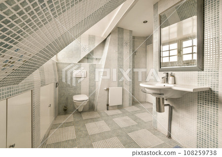 a bathroom with blue and white mosaic tiles on the walls, along with a sink and toilet in the corner 108259738