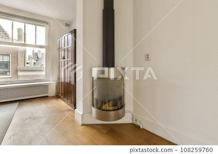 a living room with a wood floor and a fire place in the middle of the room that is on the wall 108259760