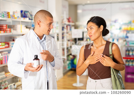 Woman complaining about heartache to pharmacist 108260090