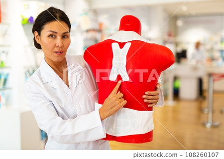 Woman doctor in drugstore with mannequin 108260107