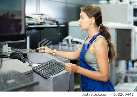 Hardware store employee combining just the right tints of paint in an electronically guided modern mixing machine 108260441