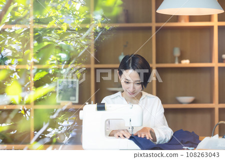 A woman using a sewing machine A woman using a sewing machine 108263043