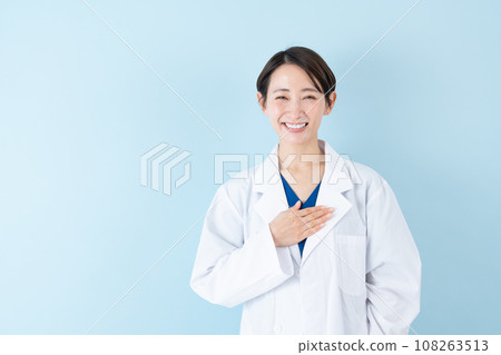 Female doctor with hand on chest, blue background Female doctor with hand on chest, blue background 108263513