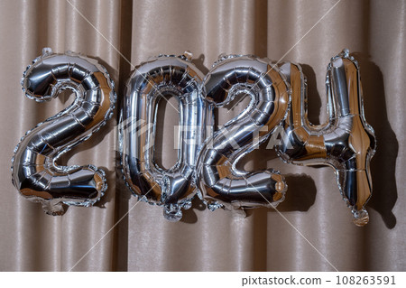 Happy new year 2024 metallic balloons on atlas textile background. Greeting card silver foil balloons numbers Christmas holiday concept. Celebration party congratulation Happy new year 2024 metallic balloons on atlas textile background. Greeting card silver foil balloons numbers Christmas holiday concept. Celebration party congratulation 108263591