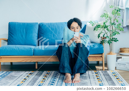年輕人在客廳使用智慧型手機 108266650