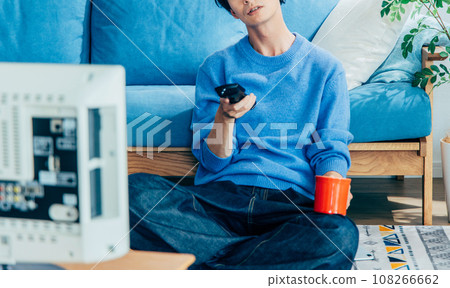 young man watching tv at home young man watching tv at home 108266662