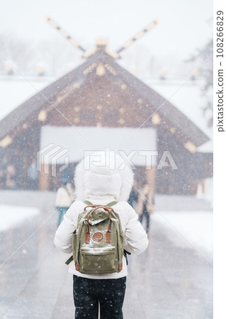 Woman tourist Visiting in Sapporo, Traveler in Sweater looking Hokkaido Shrine with Snow in winter season. landmark and popular for attractions in Hokkaido, Japan. Travel and Vacation concept 108266829