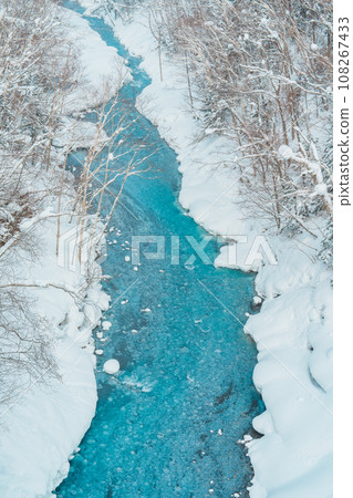 Shirahige Waterfall with Snow in winter, Biei river flow into Blue Pond. landmark and popular for attractions in Hokkaido, Japan. Travel and Vacation concept 108267433