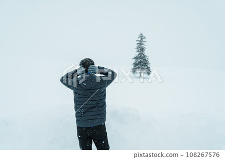 man tourist Visiting in Biei, Traveler in Sweater sightseeing Christmas tree with Snow in winter season. landmark and popular for attractions in Hokkaido, Japan. Travel and Vacation concept 108267576