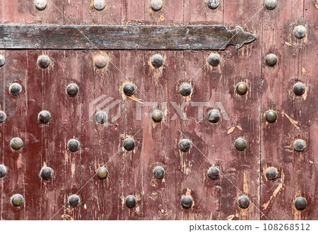 Detail of old wooden gate leaf part. Ancient wood door with metal rivets in Qaitbay Citadel, Alexandria, Egypt Detail of old wooden gate leaf part. Ancient wood door with metal rivets in Qaitbay Citadel, Alexandria, Egypt 108268512