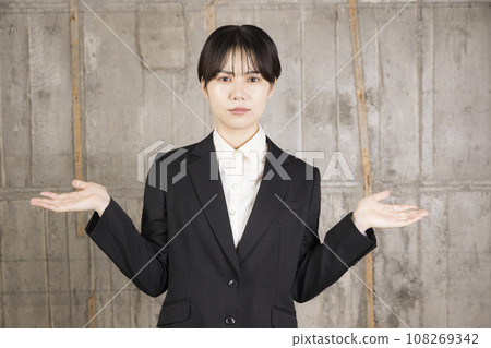 一位穿著西裝、舉起雙手的年輕女子 108269342