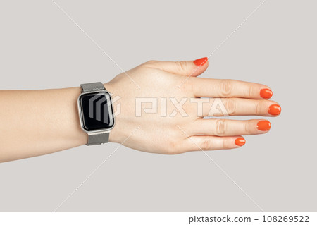 Closeup of woman hand with smartwatch with empty display handshaking with partner. Indoor studio shot isolated on gray background. 108269522