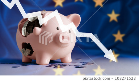down arrow and broken piggy bank on Flag of European union. decline in economic indicators in Europe, inflation, stagnation, depression, crisis. arrow falls on background of EU European flag down arrow and broken piggy bank on Flag of European union. decline in economic indicators in Europe, inflation, stagnation, depression, crisis. arrow falls on background of EU European flag 108271528