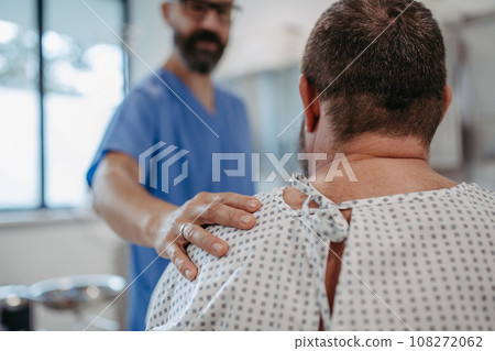 Supportive doctor soothing a worried overweight patient, discussing test result in emergency room. Illnesses and diseases in middle-aged men's health. Compassionate physician supporting stressed 108272062
