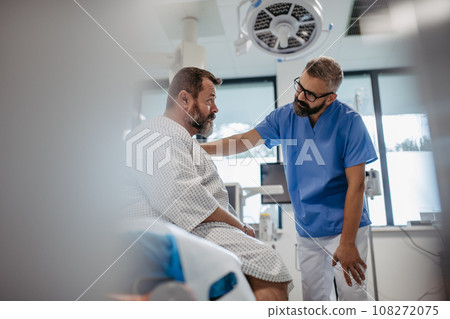 Supportive doctor soothing a worried overweight patient, discussing test result in emergency room. Illnesses and diseases in middle-aged men's health. Compassionate physician supporting stressed Supportive doctor soothing a worried overweight patient, discussing test result in emergency room. Illnesses and diseases in middle-aged men's health. Compassionate physician supporting stressed 108272075