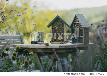 Wooden insect house outdoors in the garden. Bug hotel as home for various species of insects, garden ecosystem and biodiversity. DIY project. Wooden insect house outdoors in the garden. Bug hotel as home for various species of insects, garden ecosystem and biodiversity. DIY project. 108272527