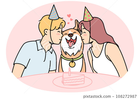 Girl, guy sit at festive table with cake, kiss dog. Girl, guy sit at festive table with cake, kiss dog. 108272987