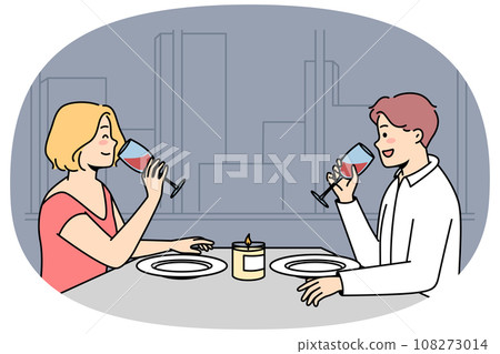 Man, woman sit at table, drink red wine in restaurant. 108273014
