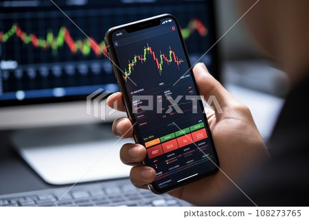 Crypto trader holds smartphone with fluctuating digital currency market to become informed 108273765