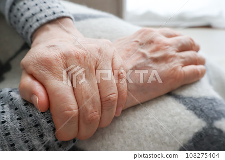 老婦人的手抓住她的右手腕 老婦人的手抓住她的右手腕 108275404