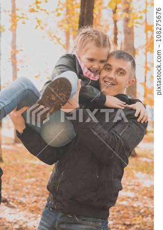 Happy father and daughter playing and having fun in a beautiful autumn park. Ideal weekend father with his little daughter 108275676