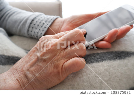 操作智慧型手機的資深婦女的手 操作智慧型手機的資深婦女的手 108275981
