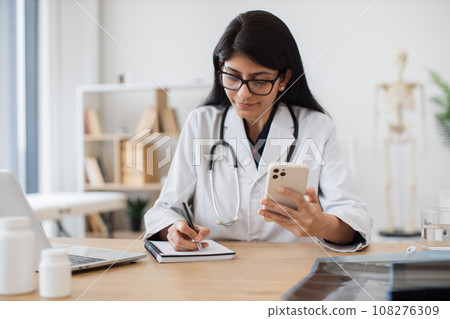 Female medic making consultation online using smartphone 108276309