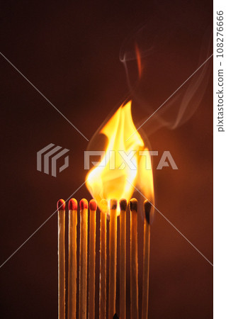 a row of matches are lit on a dark background 108276666