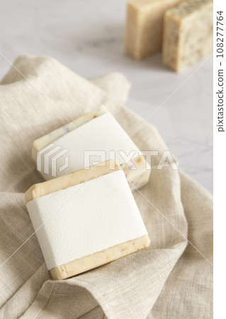 Beige handmade soap bars with blank label on linen towel close up, mockup 108277764