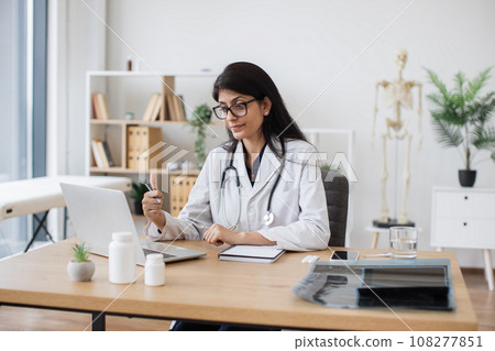 Doctor using laptop for video call with patient at hospital Doctor using laptop for video call with patient at hospital 108277851