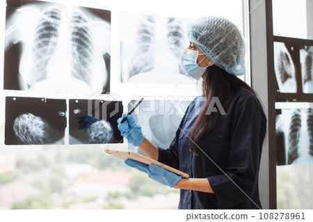 Indian doctor in mask and cap using tablet for check x-ray 108278961
