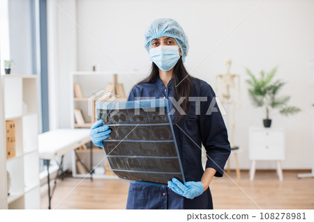 Indian female medic holding result of x-ray in hands Indian female medic holding result of x-ray in hands 108278981