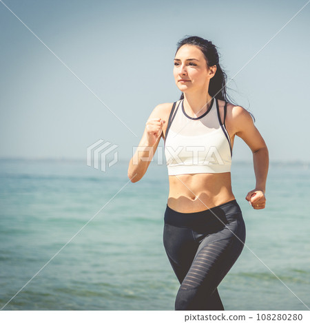 Fitness Girl running on the beach 108280280