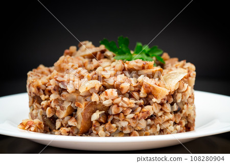 cooked buckwheat boiled with mushroom filling in a plate 108280904