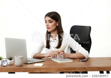 beautiful female manager using laptop computer for online work at table on beige background 108280957