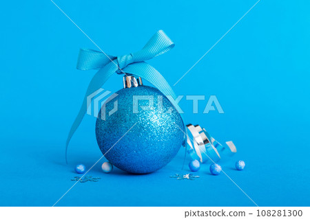 Christmas ball on colored background. decoration bauble with ribbon bow with copy space 108281300
