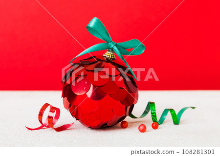 Christmas ball on colored background. decoration bauble with ribbon bow with copy space 108281301