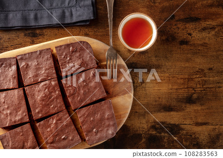 Chocolate brownie with tea, coffee cake, overhead flat lay view 108283563