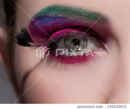 Crop of female eye with colorful make up. Beautiful fashion model with creative art makeup. Crop of female eye with colorful make up. Beautiful fashion model with creative art makeup. 108283631