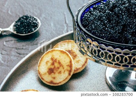 Vintage caviar dish with black caviar and blinis, a closeup on black 108283700