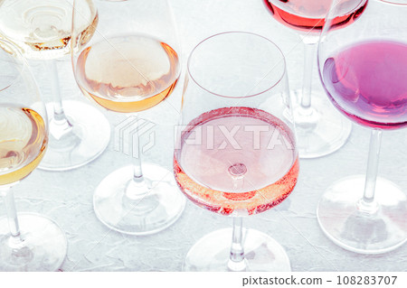 Wine glasses at a tasting. Rose, red, and white wine, drinks on a table 108283707
