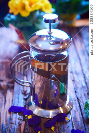Flower tea in glass pot on a wooden table. Flower tea in glass pot on a wooden table. 108284106
